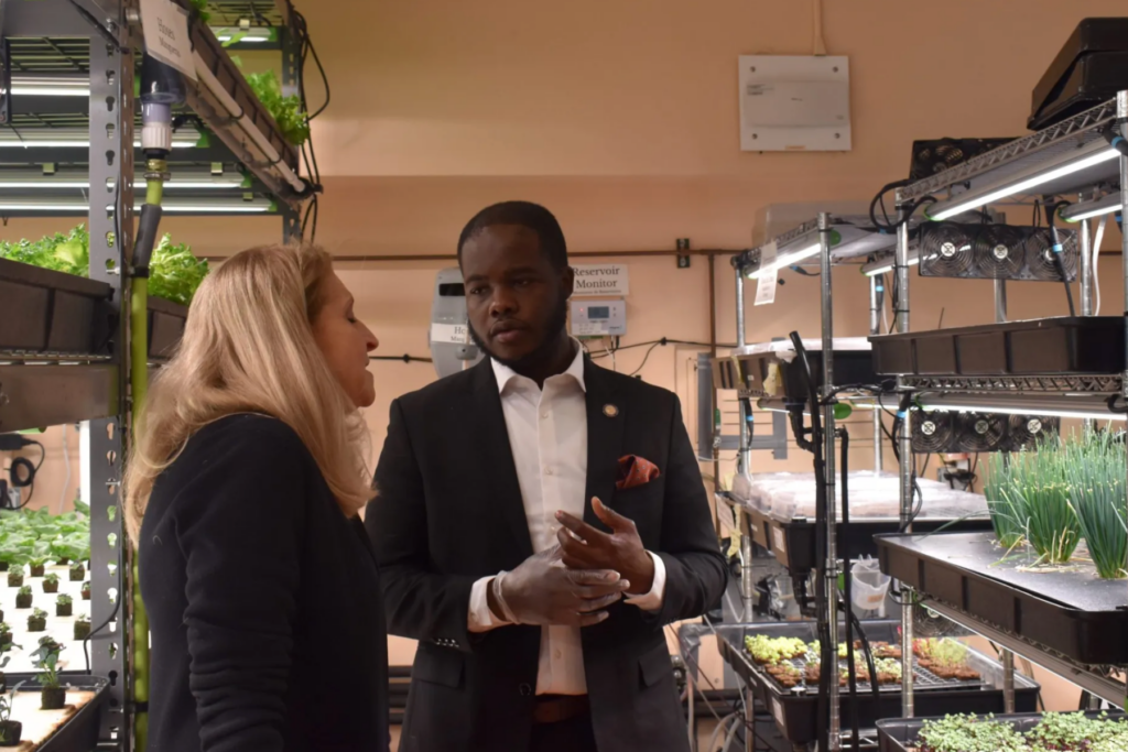 Queens Assemblymember Khaleel Anderson (right) with Teens for Food Justice Founder Katherine Soll (left) tour Far Rockaway High School’s hydroponic farm on Friday, Jan. 24. Credit: Ariama C. Long photo