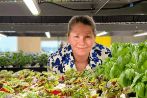 Meg smiling behind a hydroponic system